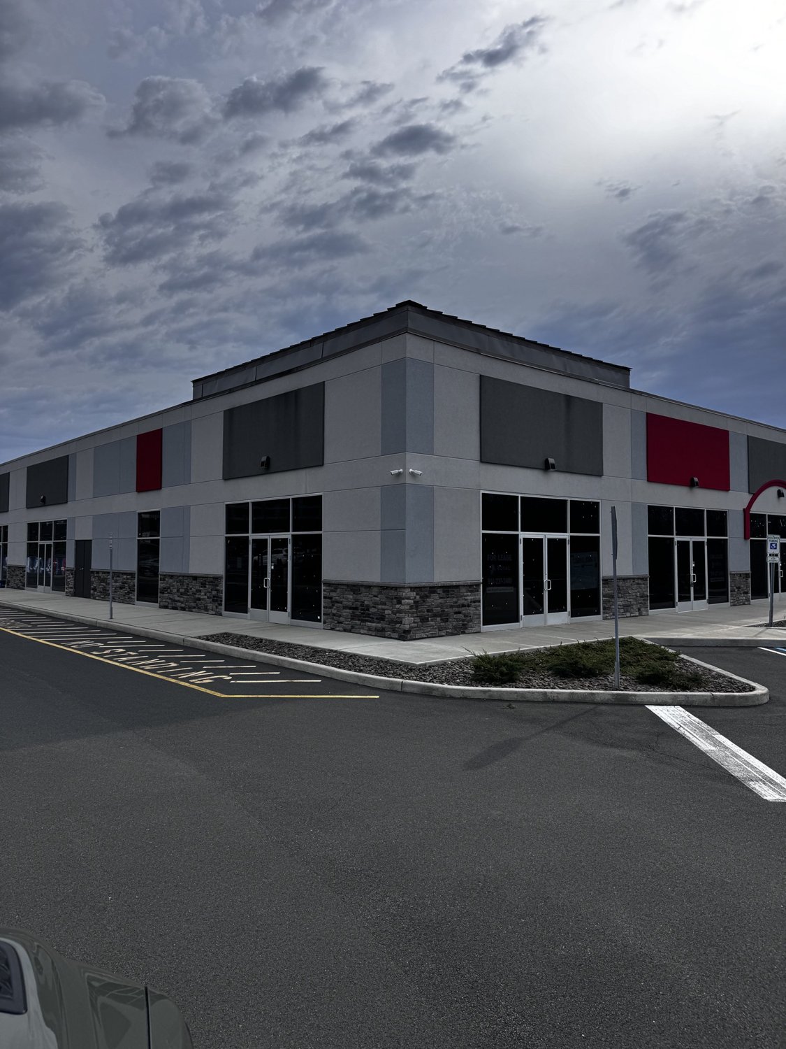 Finished commercial retail building exterior with masonry base and storefront glazing