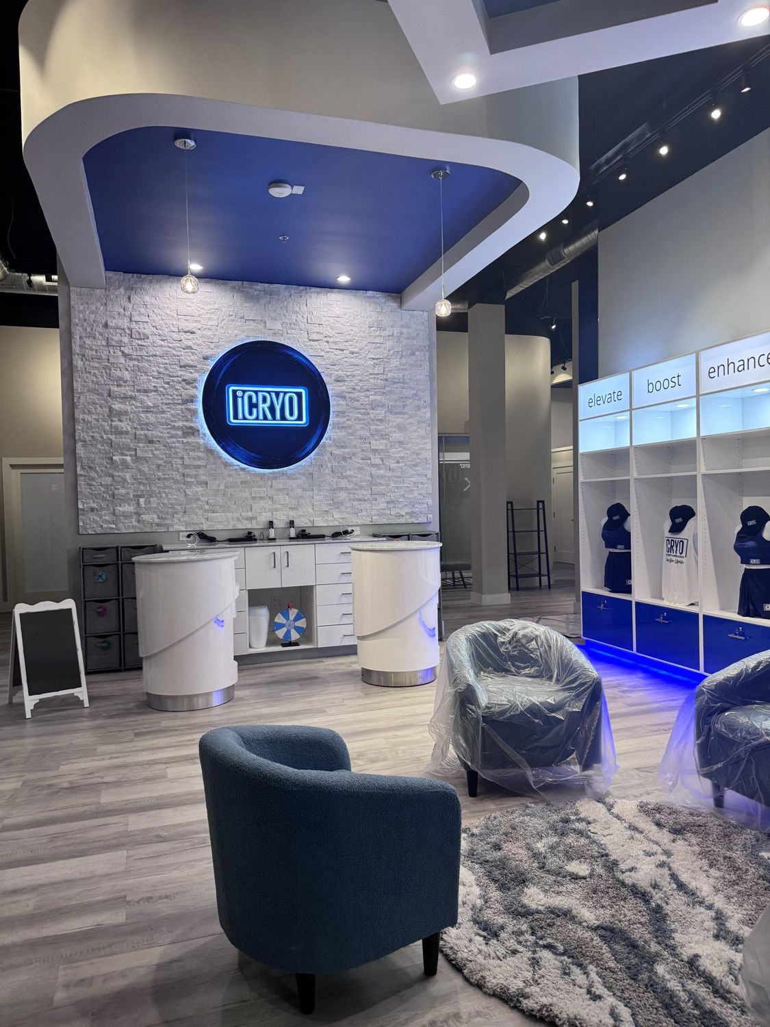 Finished commercial wellness studio interior — stacked-stone feature wall, custom curved ceiling, branded retail fixtures