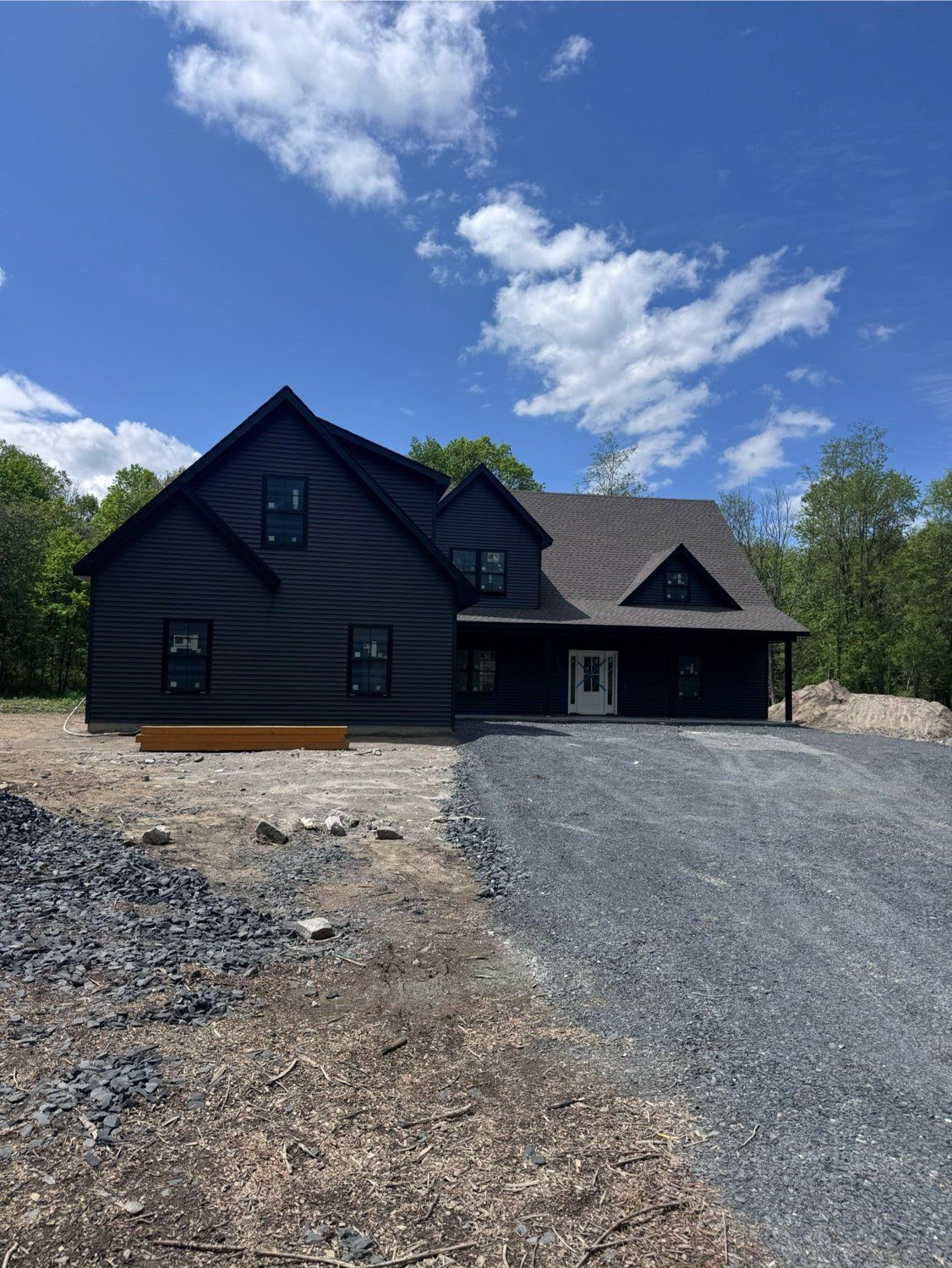 Finished custom home exterior — dark navy siding, gabled roofline