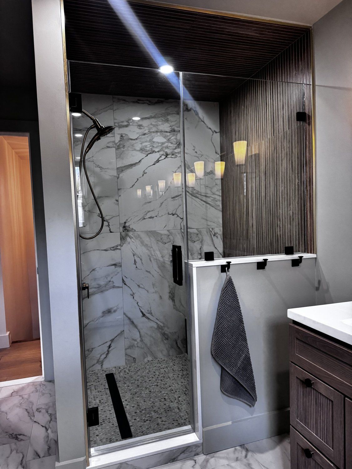 Finished walk-in shower — marble and slatted wood detailing